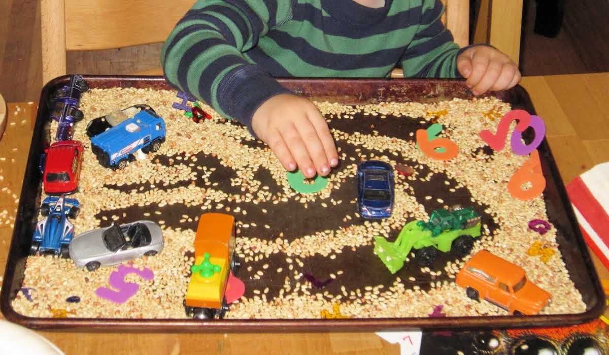 Ideas de bandejas sensoriales con coches, camiones y trenes de juguete.